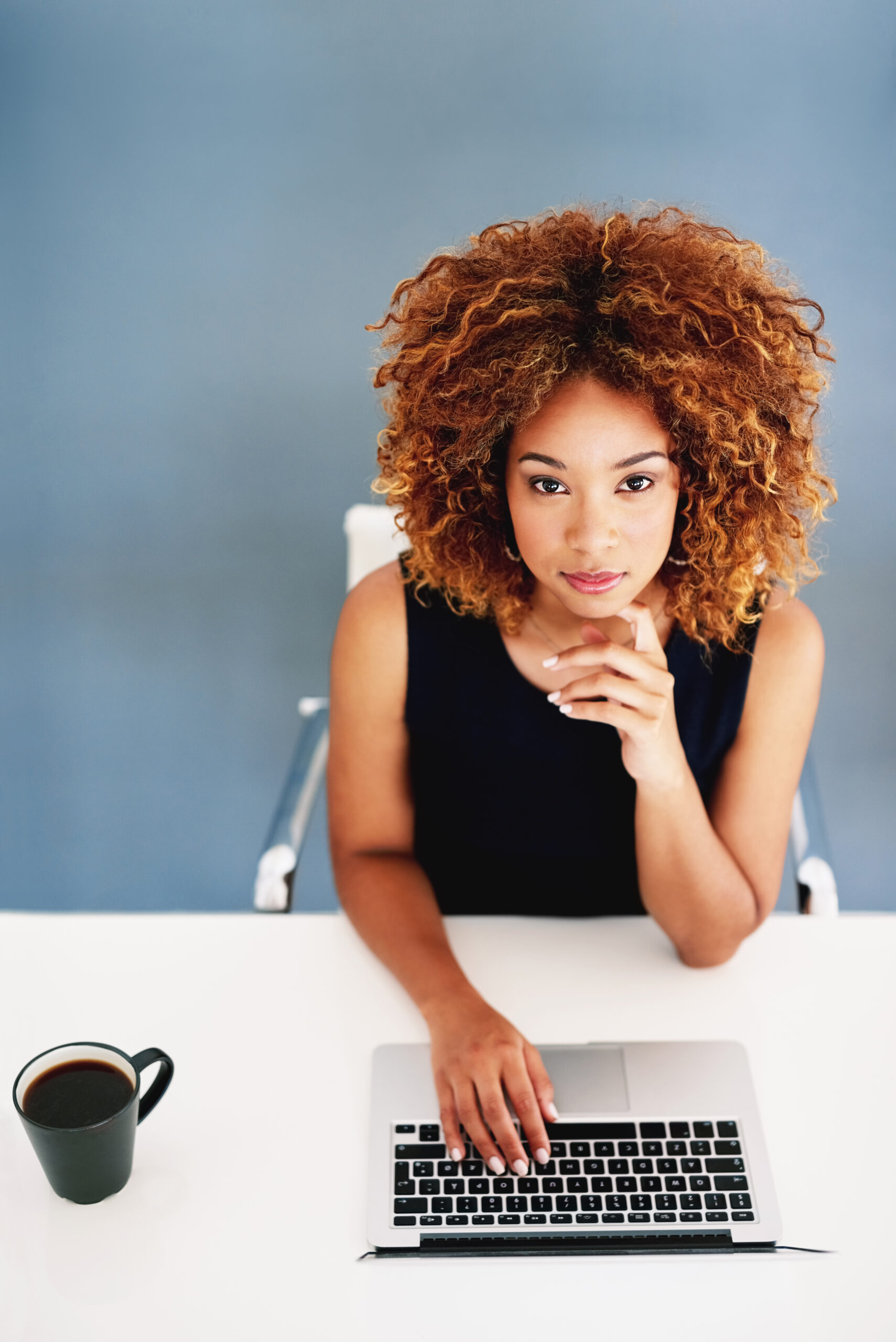 portrait of a young businesswoman working on a laptop at her desk.